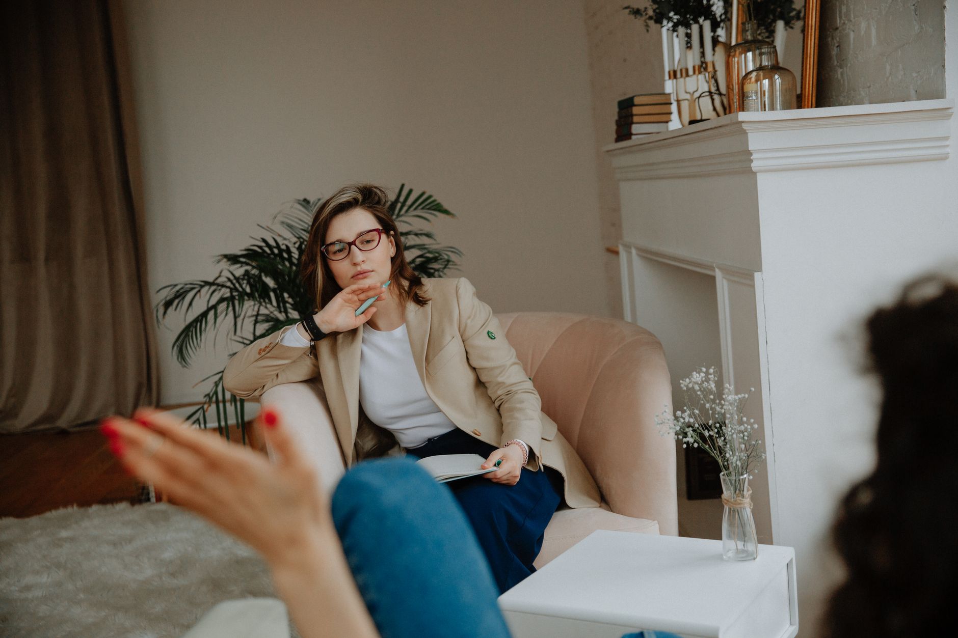 A woman counselor attentively listens during a therapy session in a cozy office environment — UPI Study
