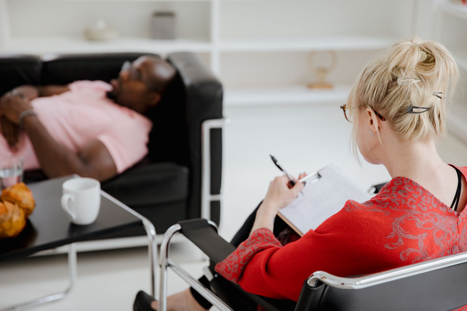 A professional therapist takes notes during a therapy session, engaging with a client — UPI Study