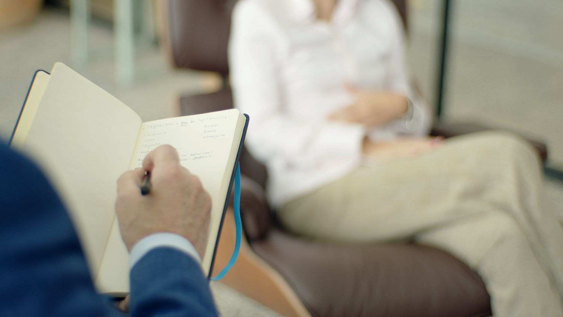 Therapist writing notes during a counseling session with a client — UPI Study