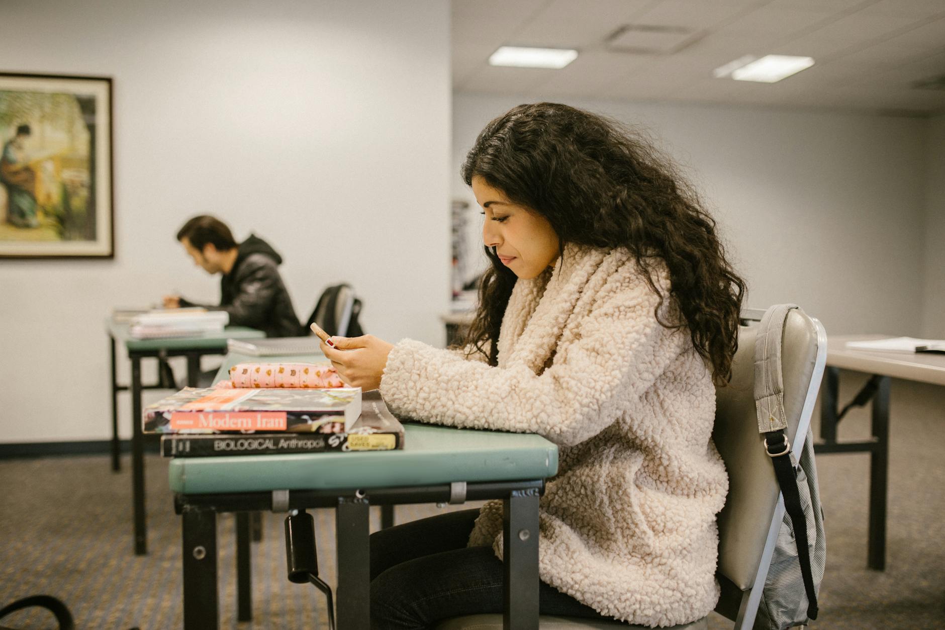 Female college student focusing on study materials in a classroom setting — UPI Study