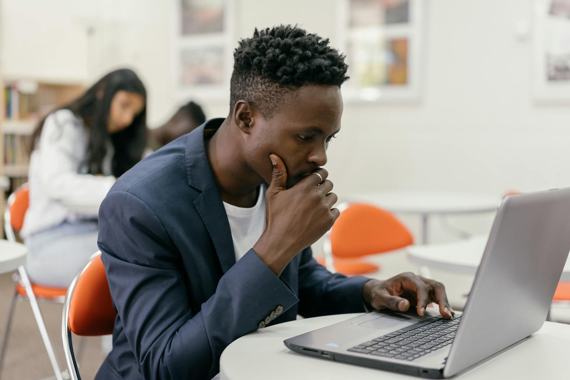 Focused student sitting at a laptop in a modern classroom setting — UPI Study