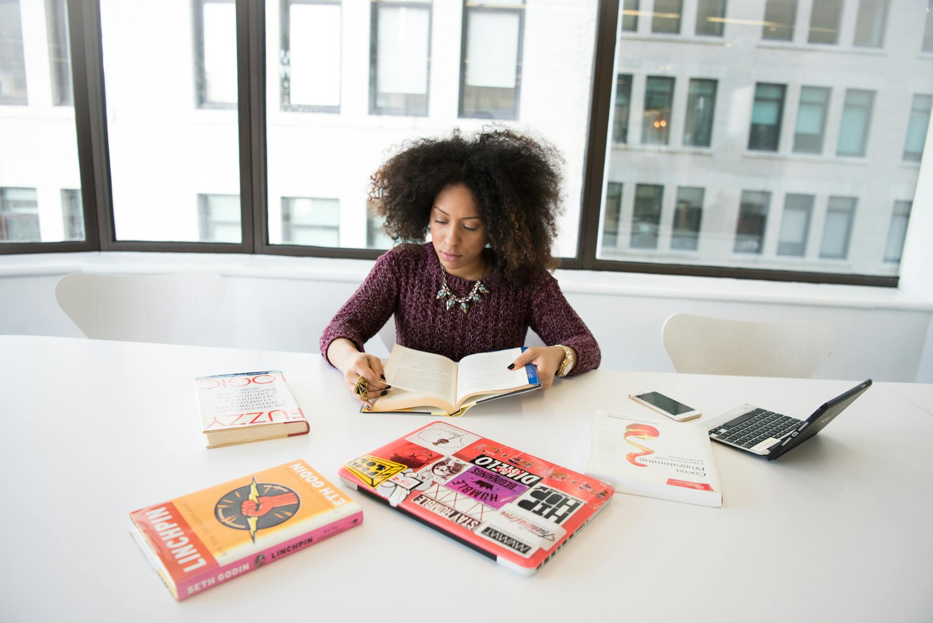 A focused woman working in an office environment, studying and reading research material — UPI Study