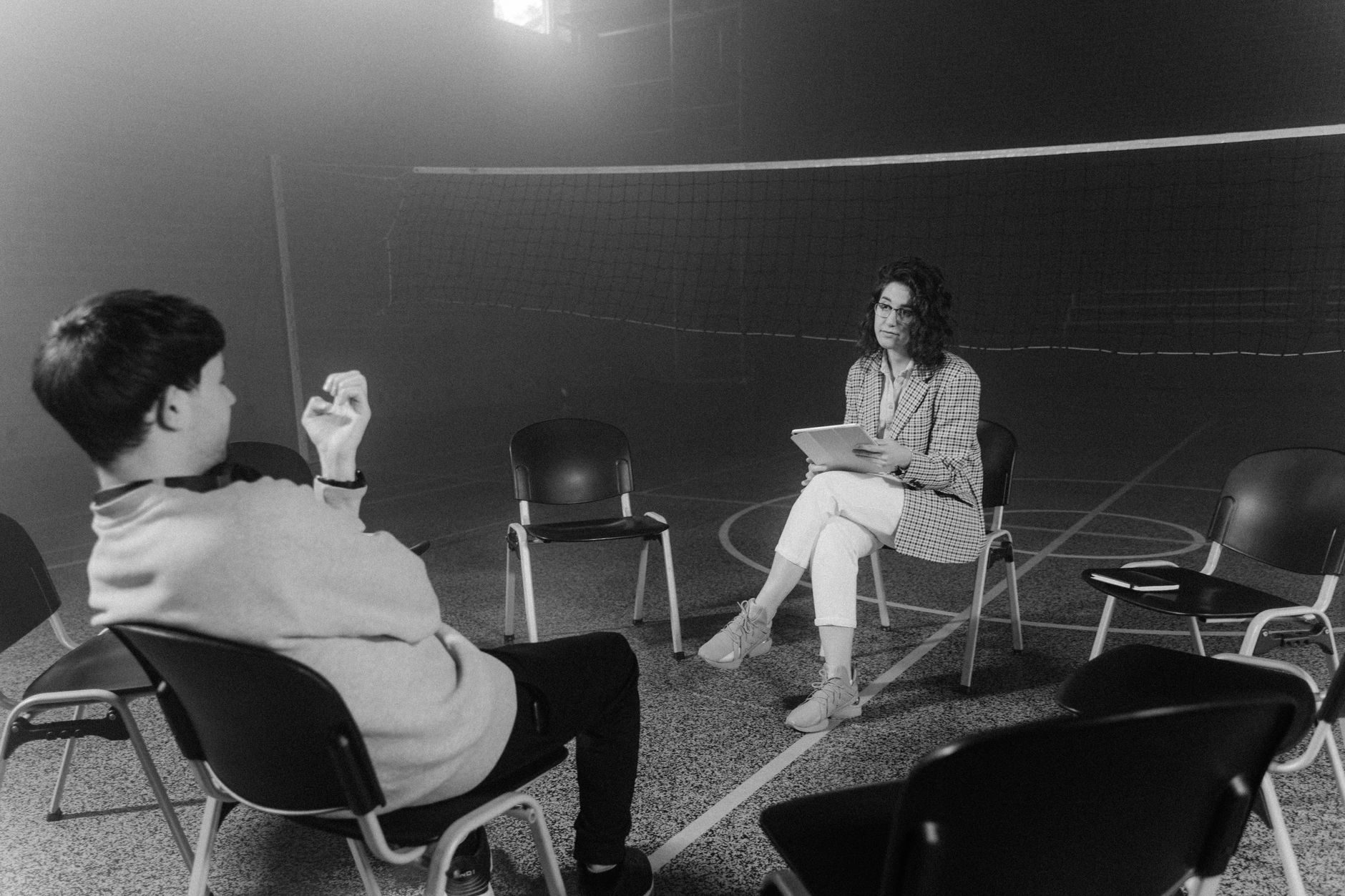 A black and white image capturing a one-on-one counseling session in an indoor setting — UPI Study