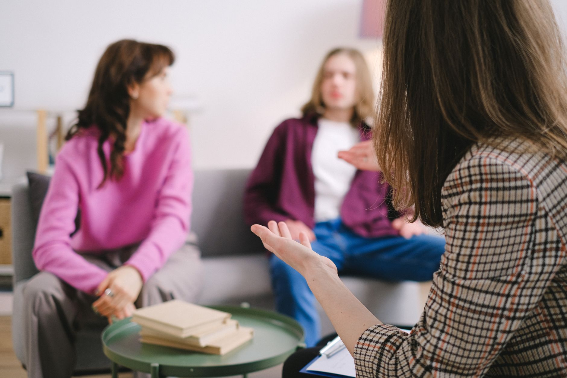 Engaged counseling session with three adults discussing together in a cozy indoor setting — UPI Study