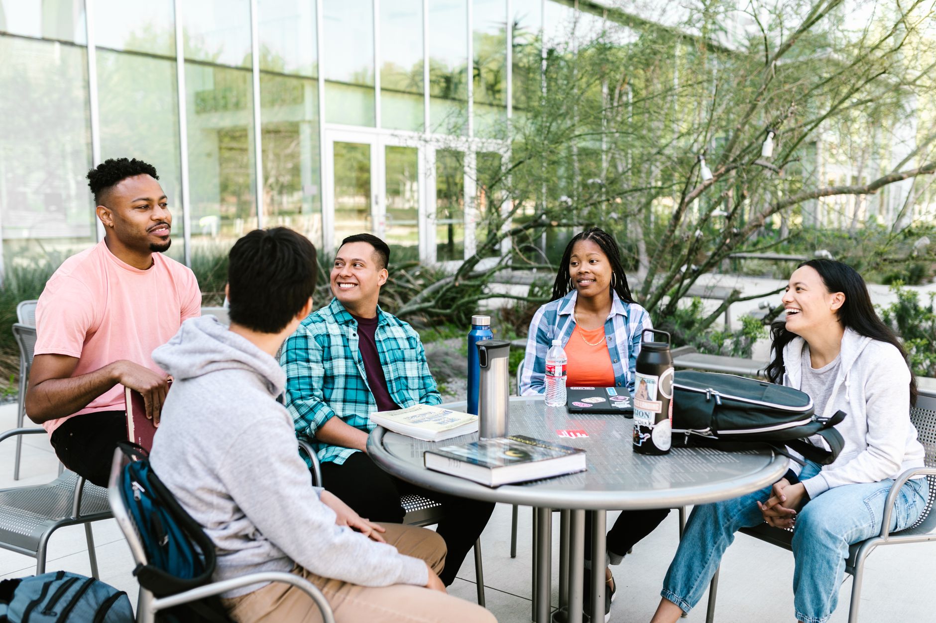 University students studying together outside at a campus table — UPI Study