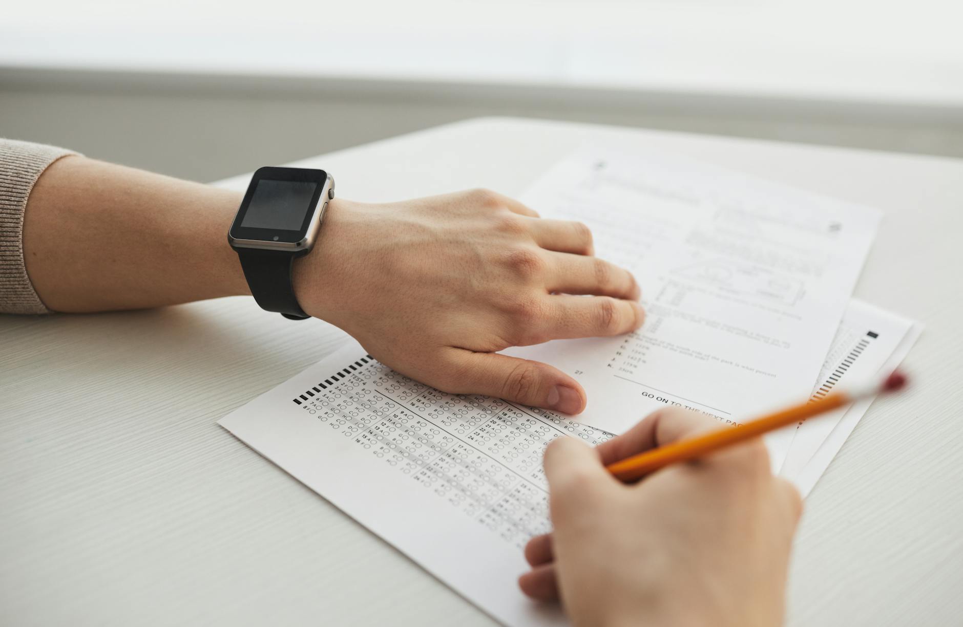 Student completing a multiple-choice exam with a pencil, close-up view — UPI Study