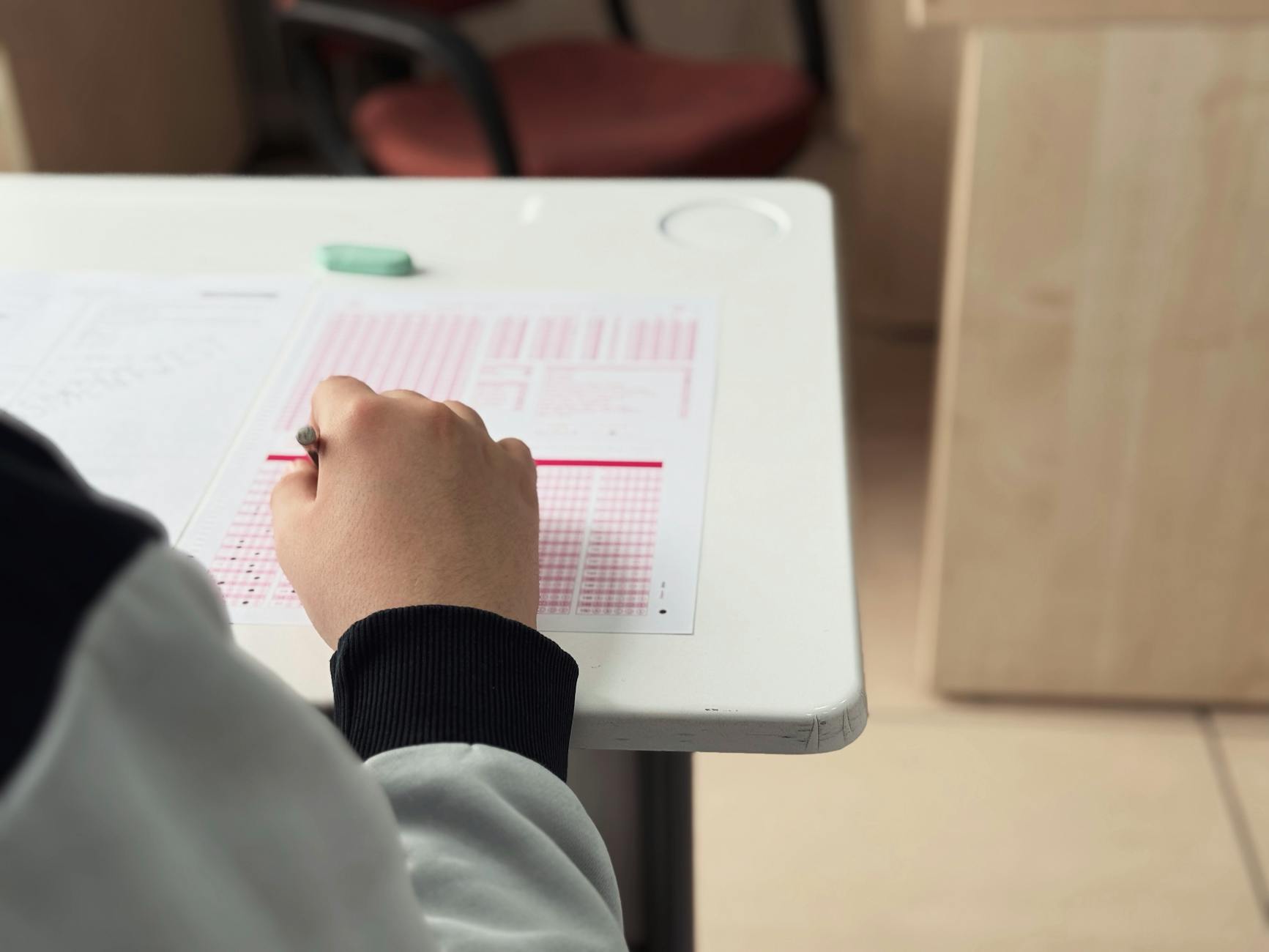 Close-up of student answering a test in a classroom environment — UPI Study