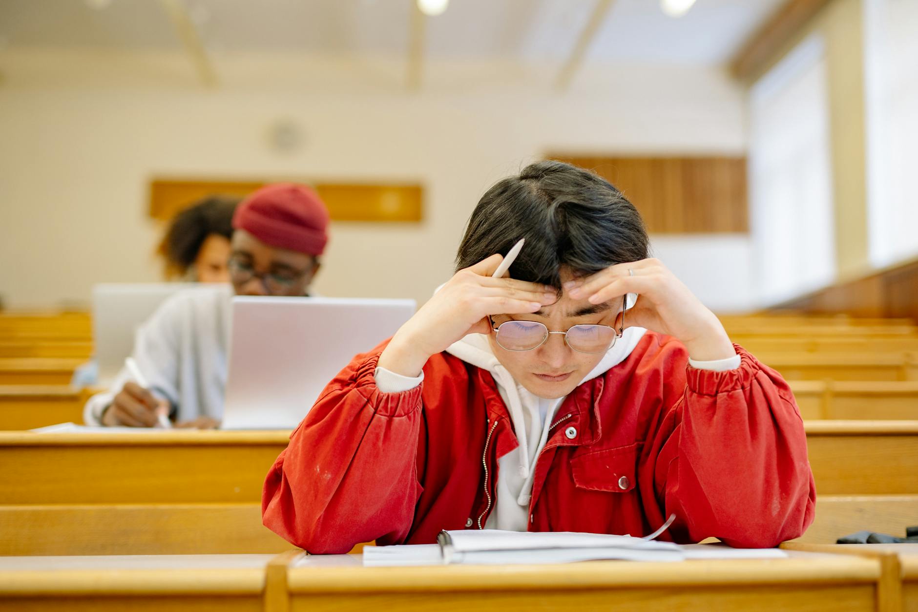 Focused students studying intensely in a university lecture hall setting — UPI Study