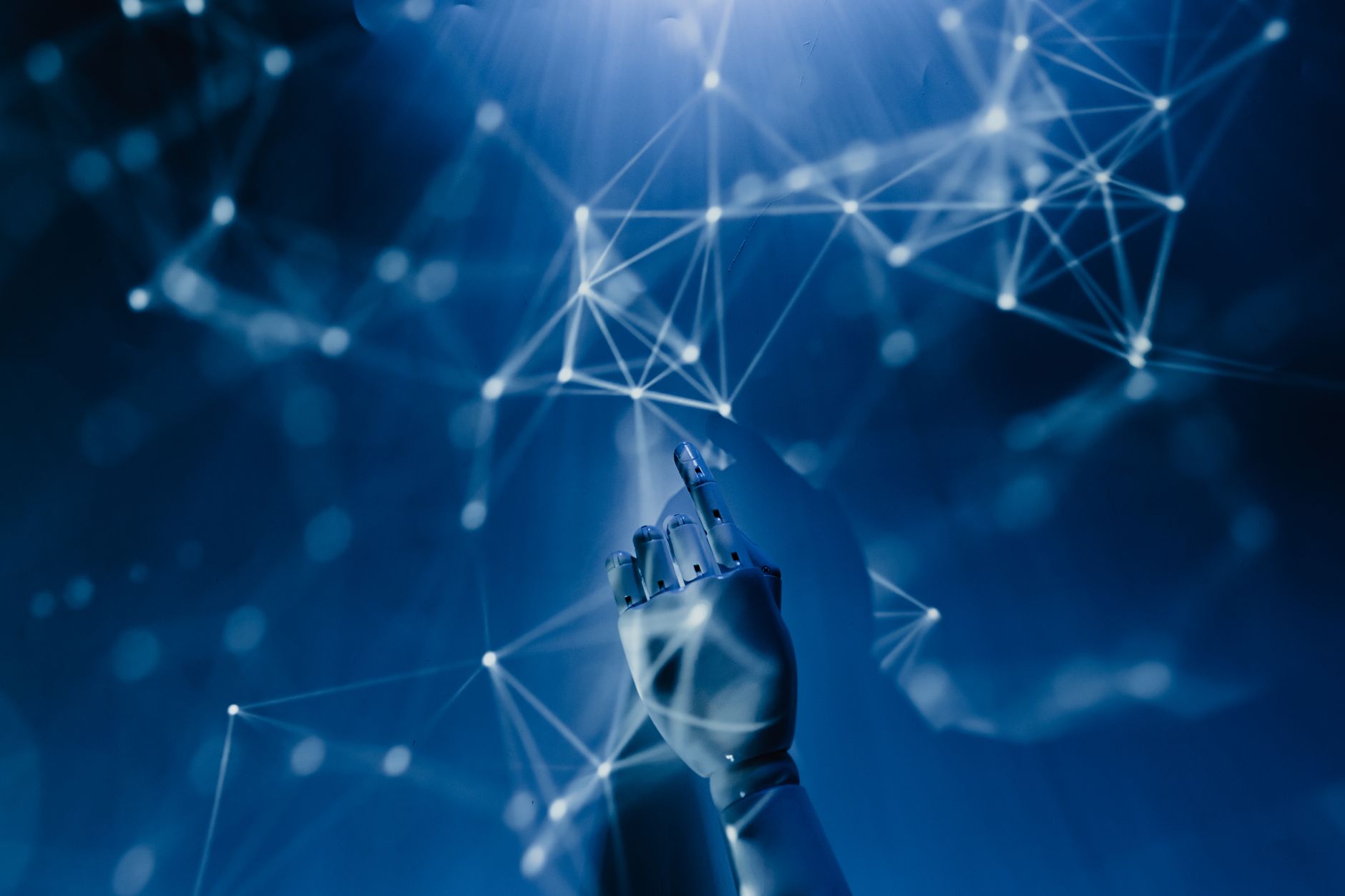 A robotic hand reaching into a digital network on a blue background, symbolizing AI technology — UPI Study