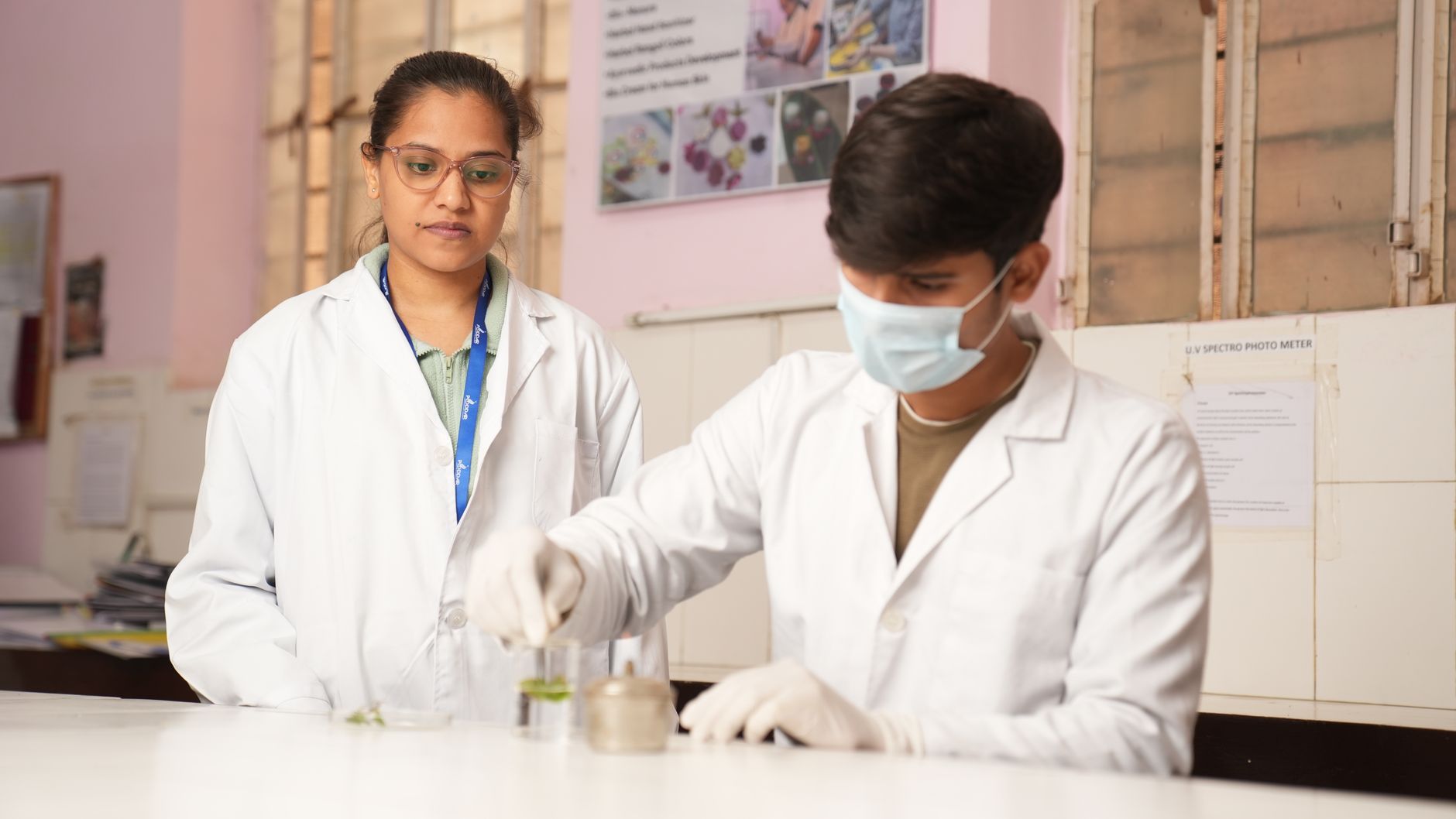 Two young scientists in lab coats performing an experiment in a laboratory setting — UPI Study