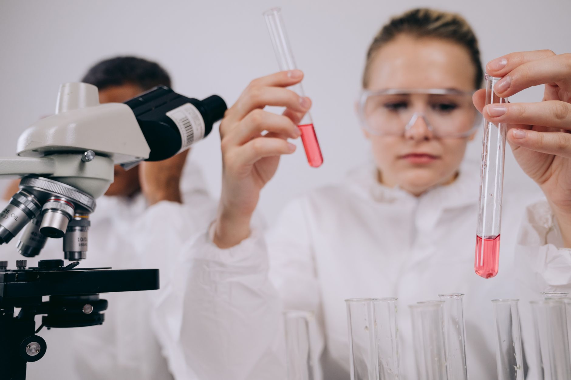 Researchers conducting experiments in a laboratory setting using microscopes and test tubes — UPI Study