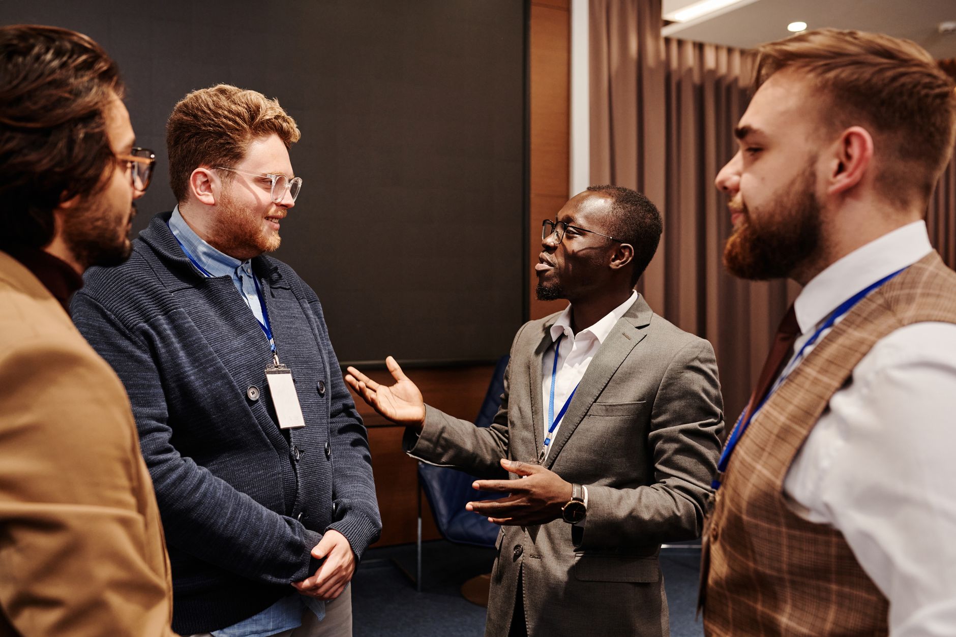 Group of diverse business professionals engaged in a lively discussion indoors — UPI Study