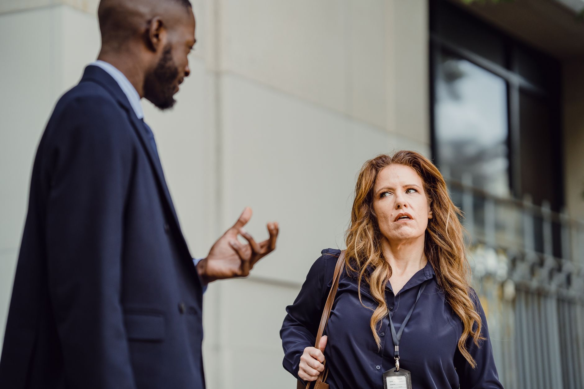 Business colleagues engage in conversation outside modern office building — UPI Study