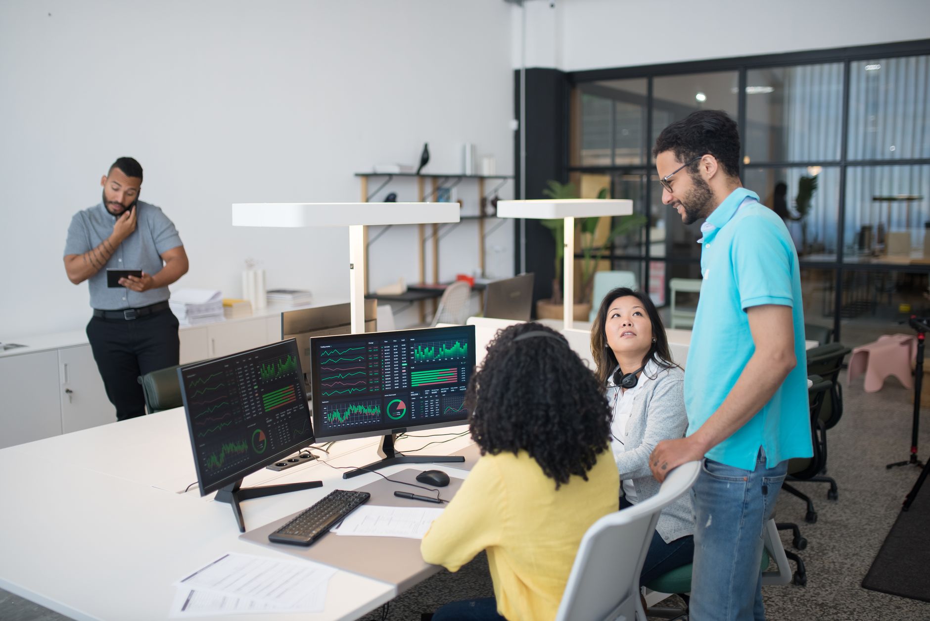 Office employees collaborate on financial data at modern workspace, engaging in teamwork and communication — UPI Study