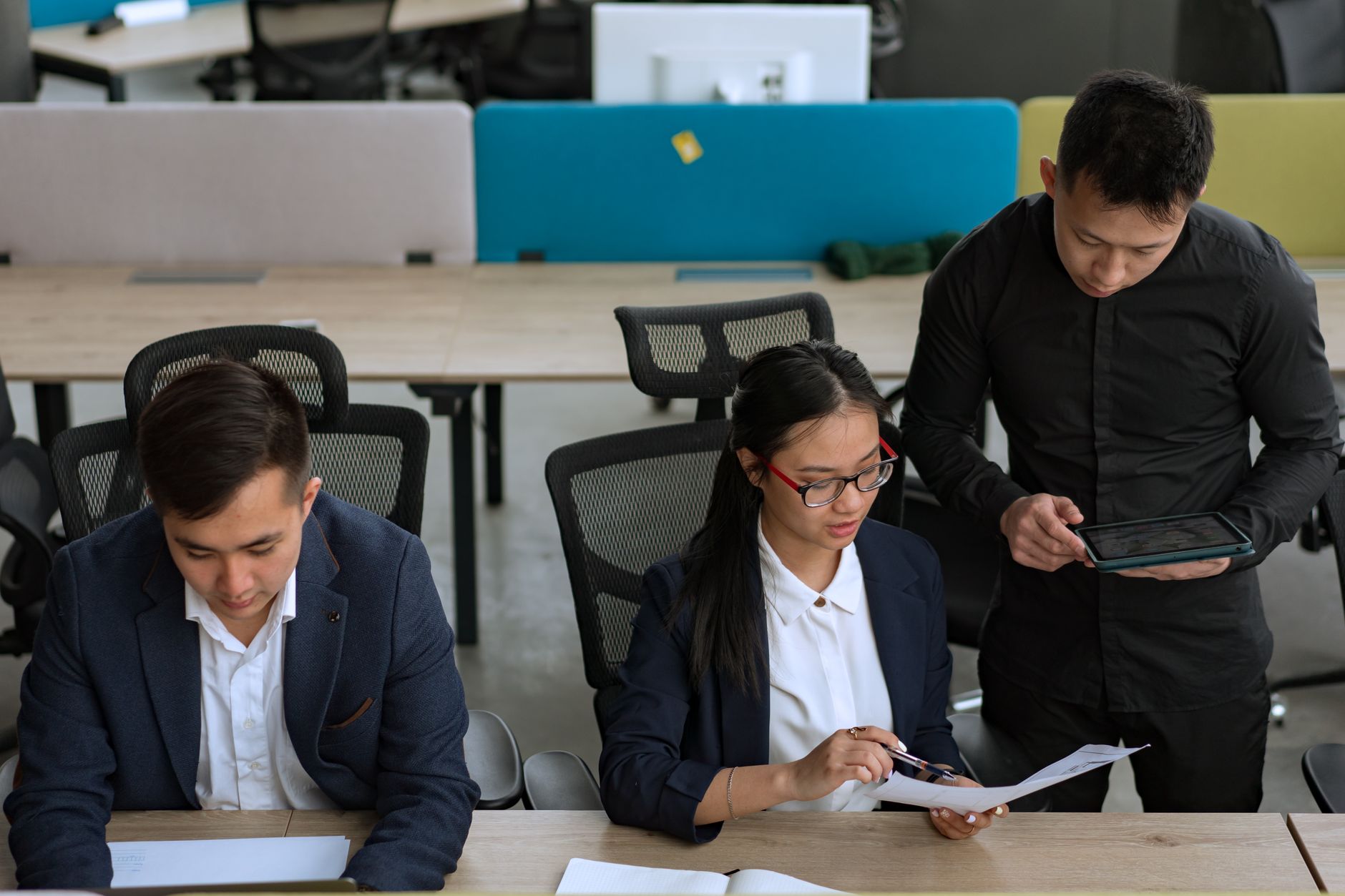 A professional team collaborating in a modern office setting, focusing on documents and technology — UPI Study
