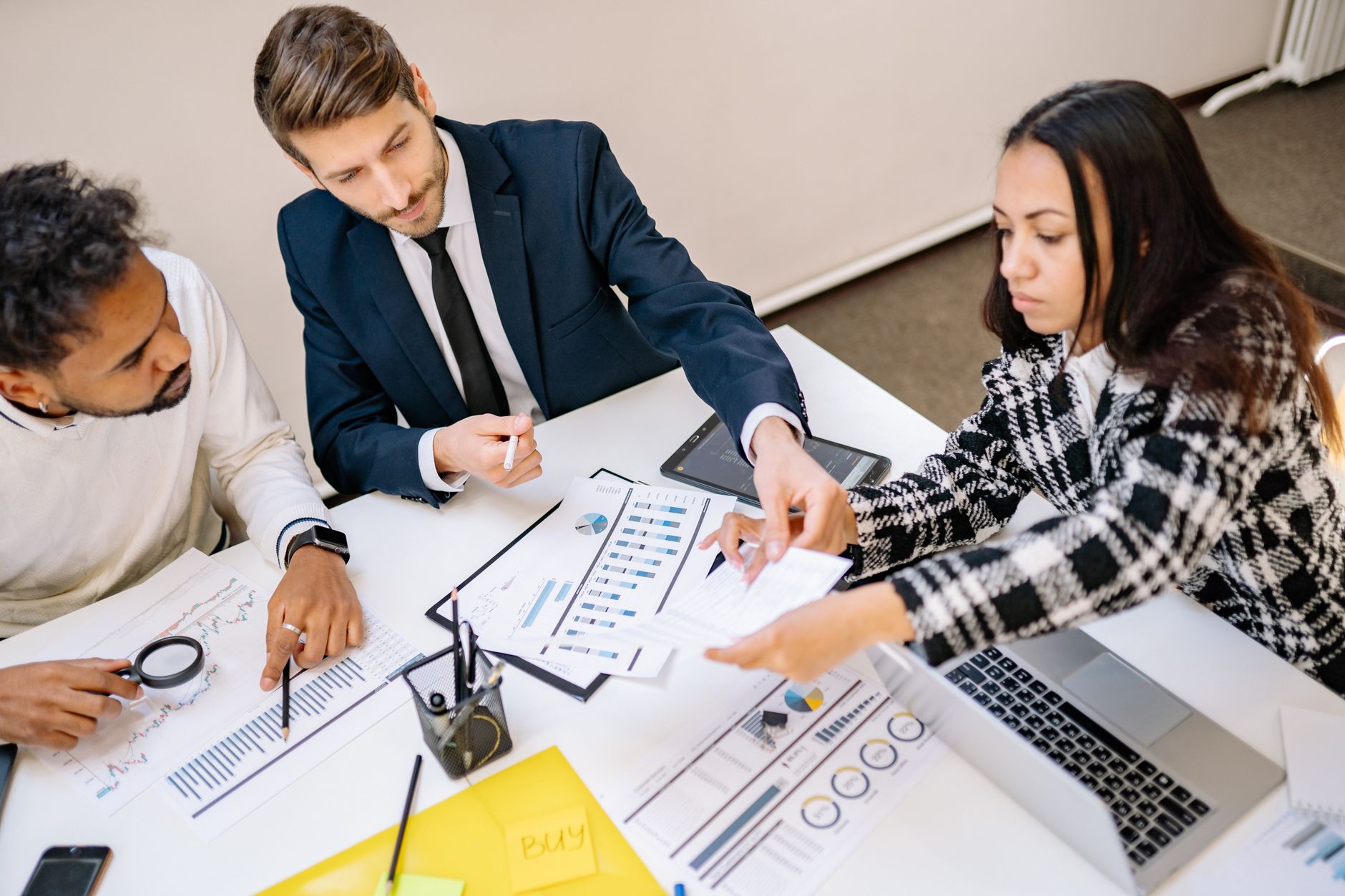 Business professionals engaging in a collaborative meeting with charts and documents — UPI Study