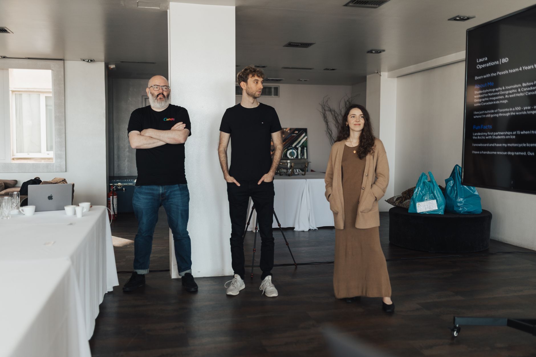 Three professionals presenting in a modern office with large screen display — UPI Study