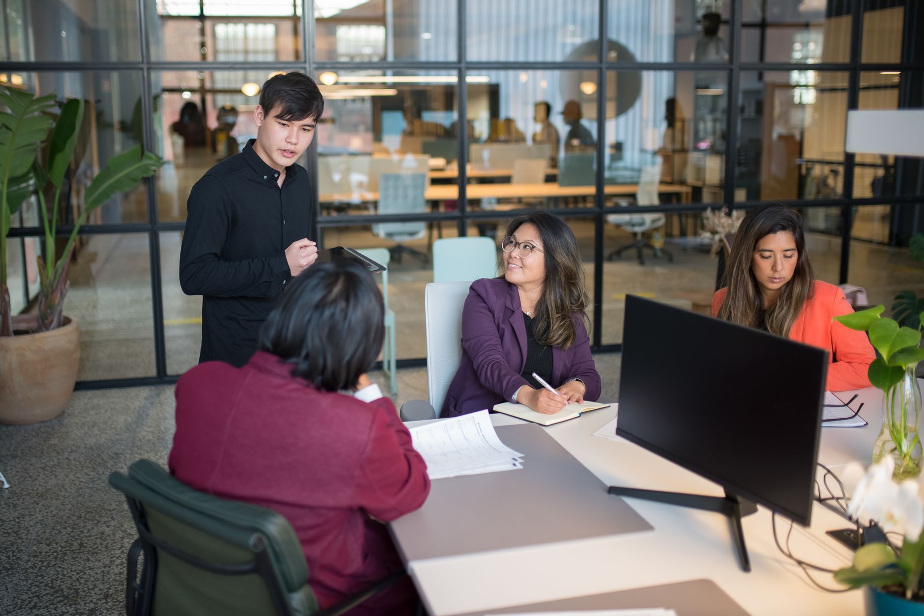 Colleagues engage in a meeting within a modern office, promoting teamwork and productivity — UPI Study