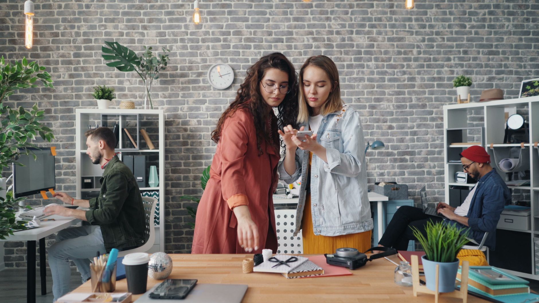 Collaborative team of men and women in a modern office workspace working on creative design projects — UPI Study
