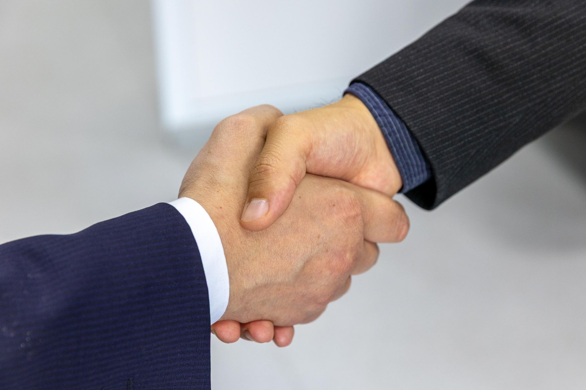 Close-up of two businessmen shaking hands, symbolizing agreement and partnership — UPI Study