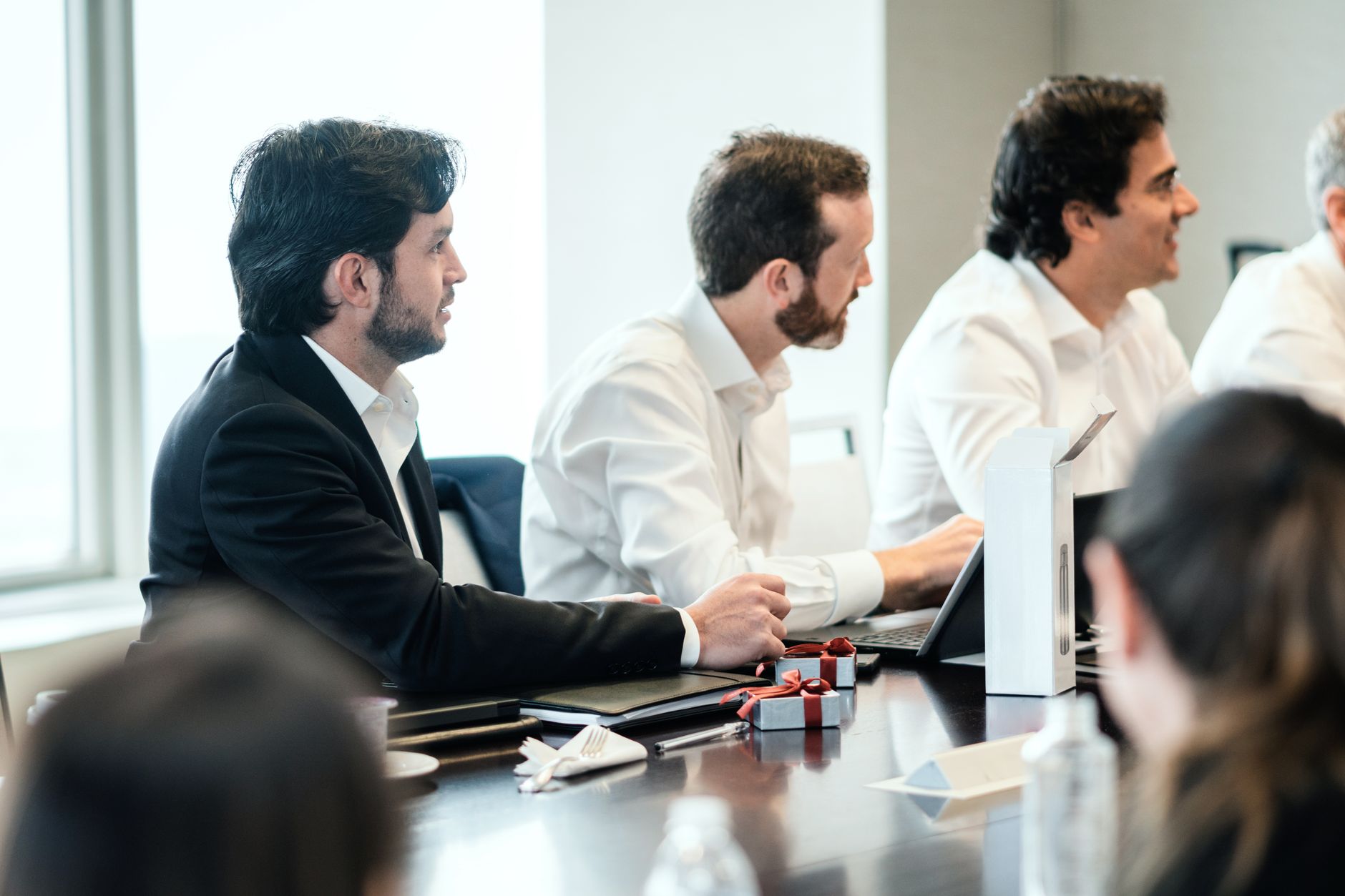 People in formal attire engaging in a collaborative business meeting — UPI Study