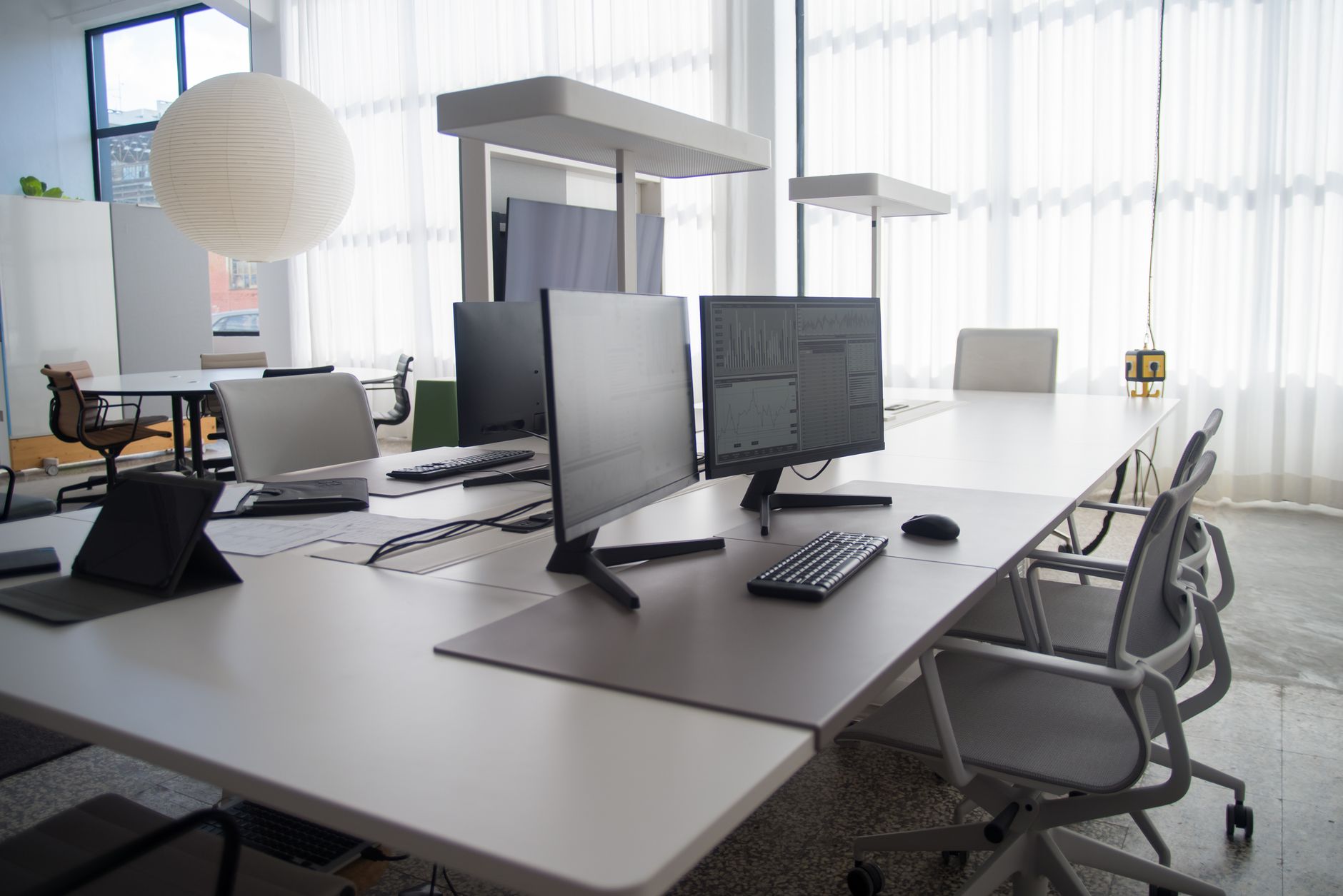 Spacious modern office featuring multiple computers, chairs, and collaborative workstations in natural light — UPI Study