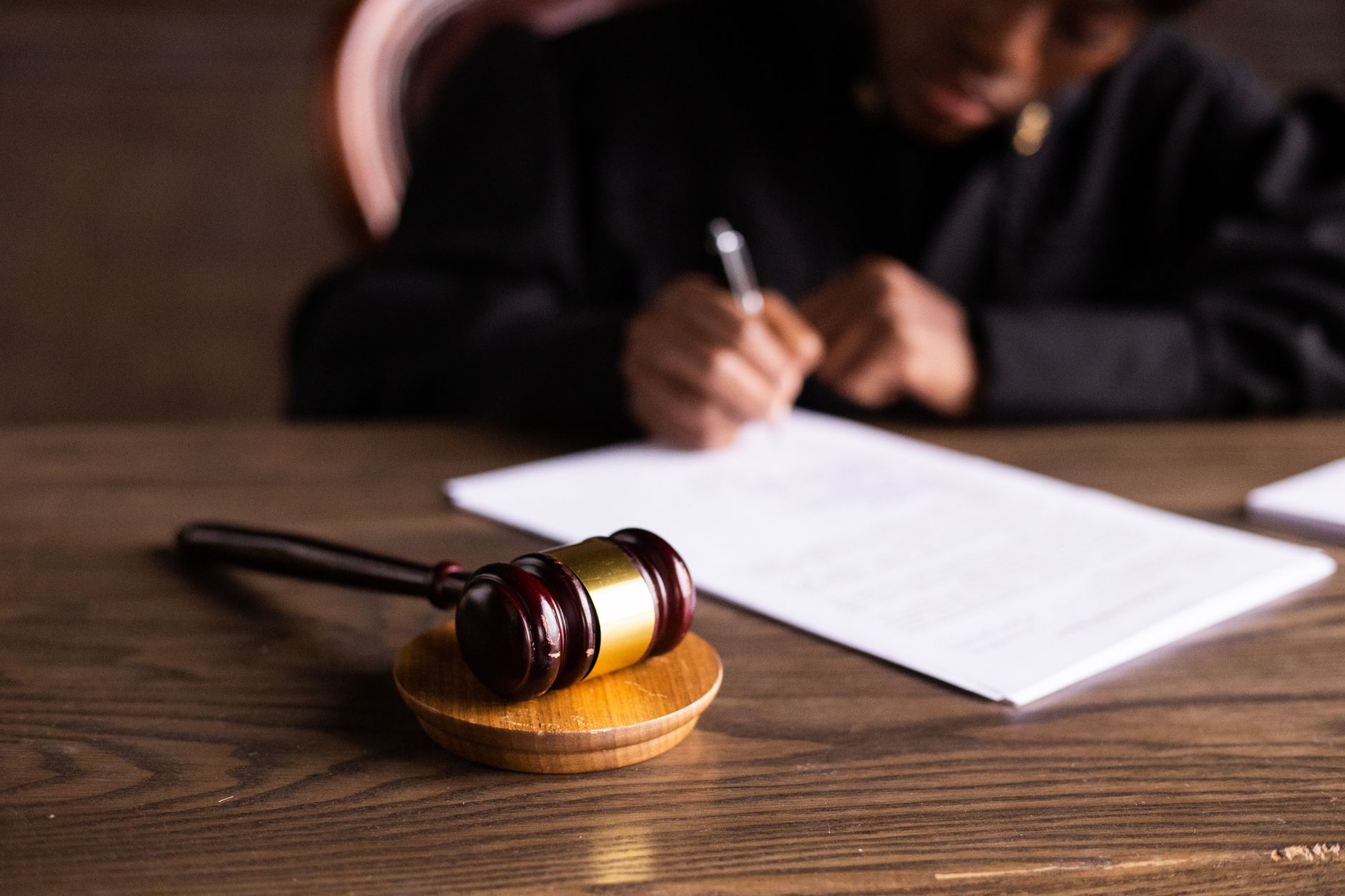 Judge signing documents at desk with focus on gavel, representing law and justice — UPI Study
