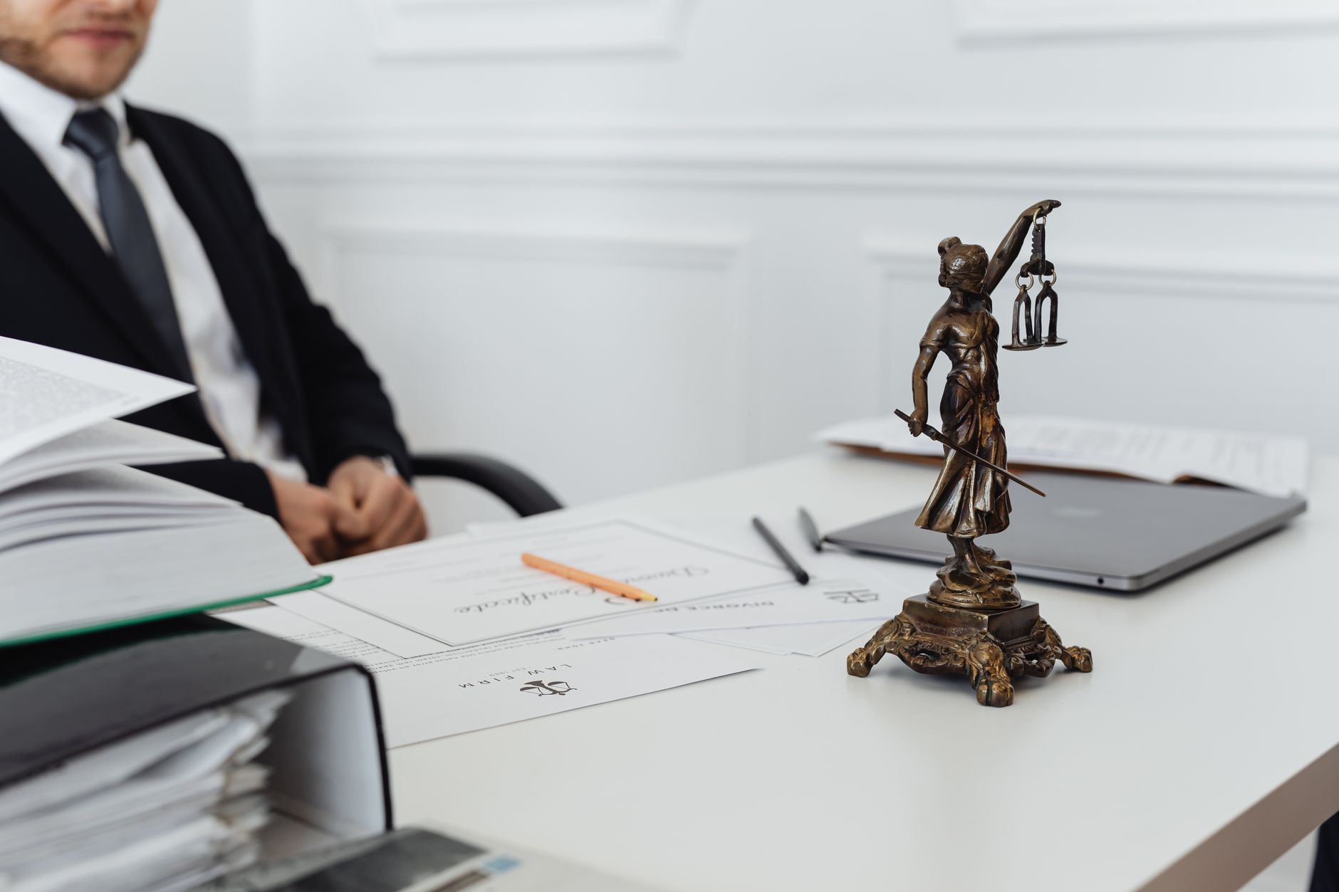 A legal professional's workspace featuring Lady Justice statue, documents, and a laptop — UPI Study