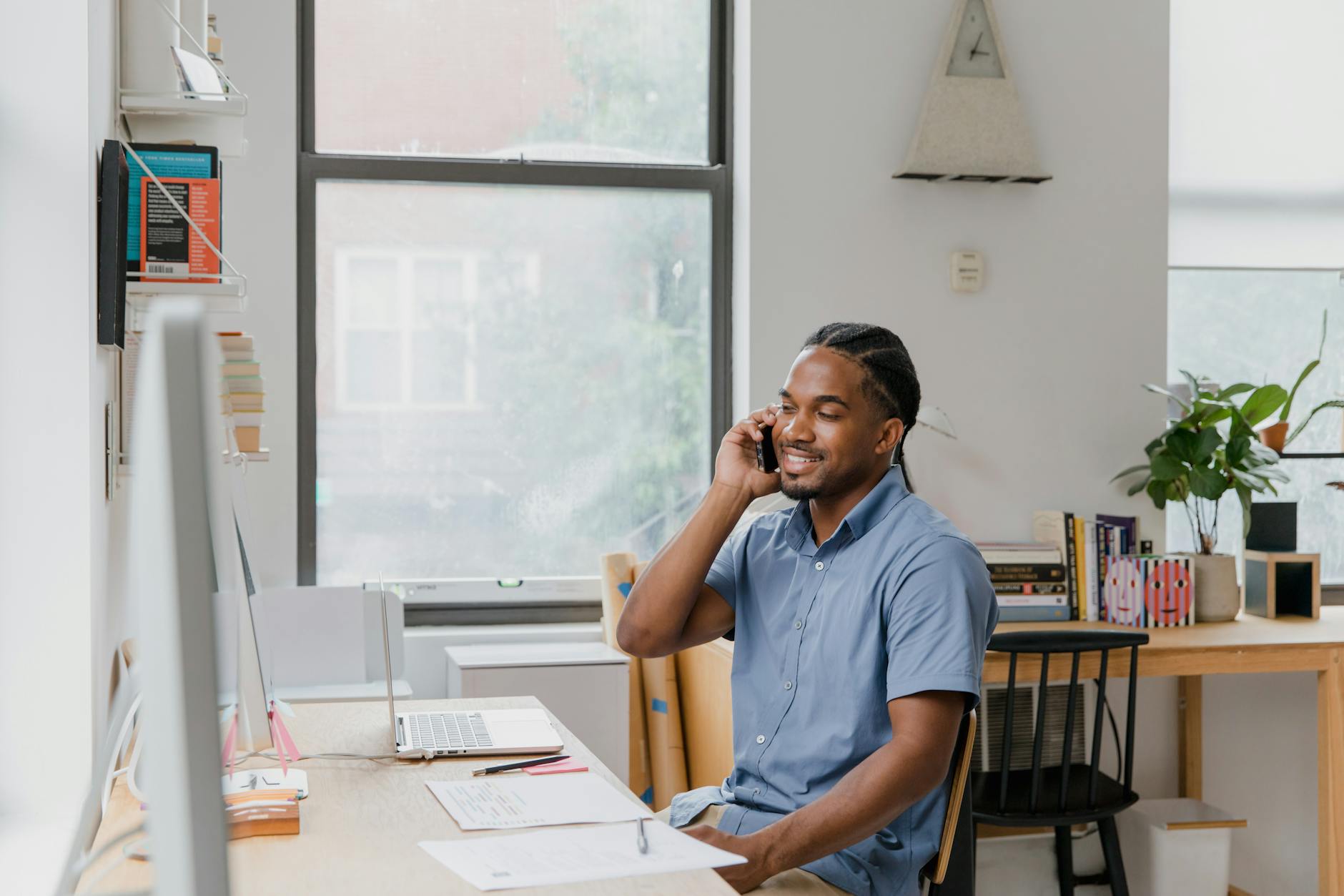 Adult man engaged in office work, speaking on phone, showcasing a professional environment — UPI Study