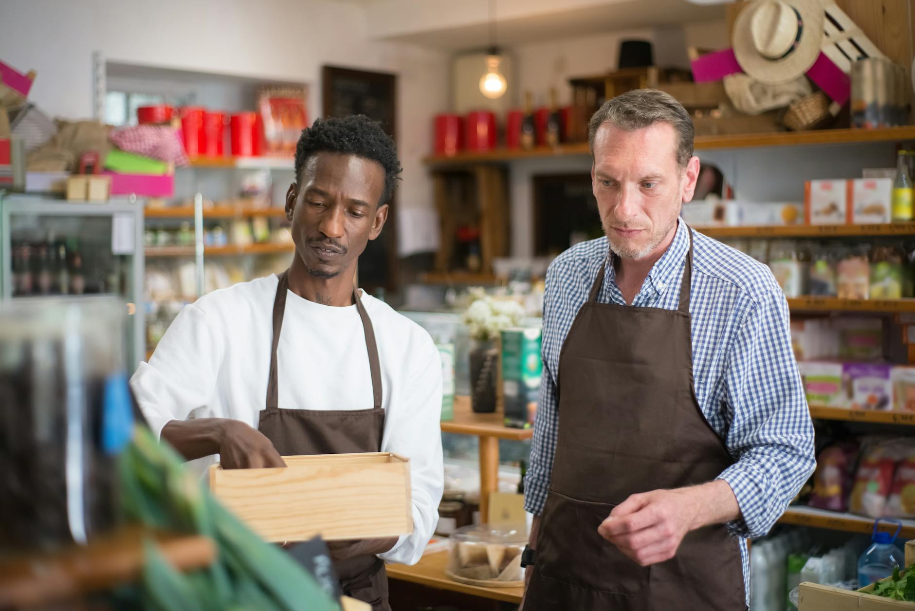 Two male employees organizing products in a cozy grocery store — UPI Study