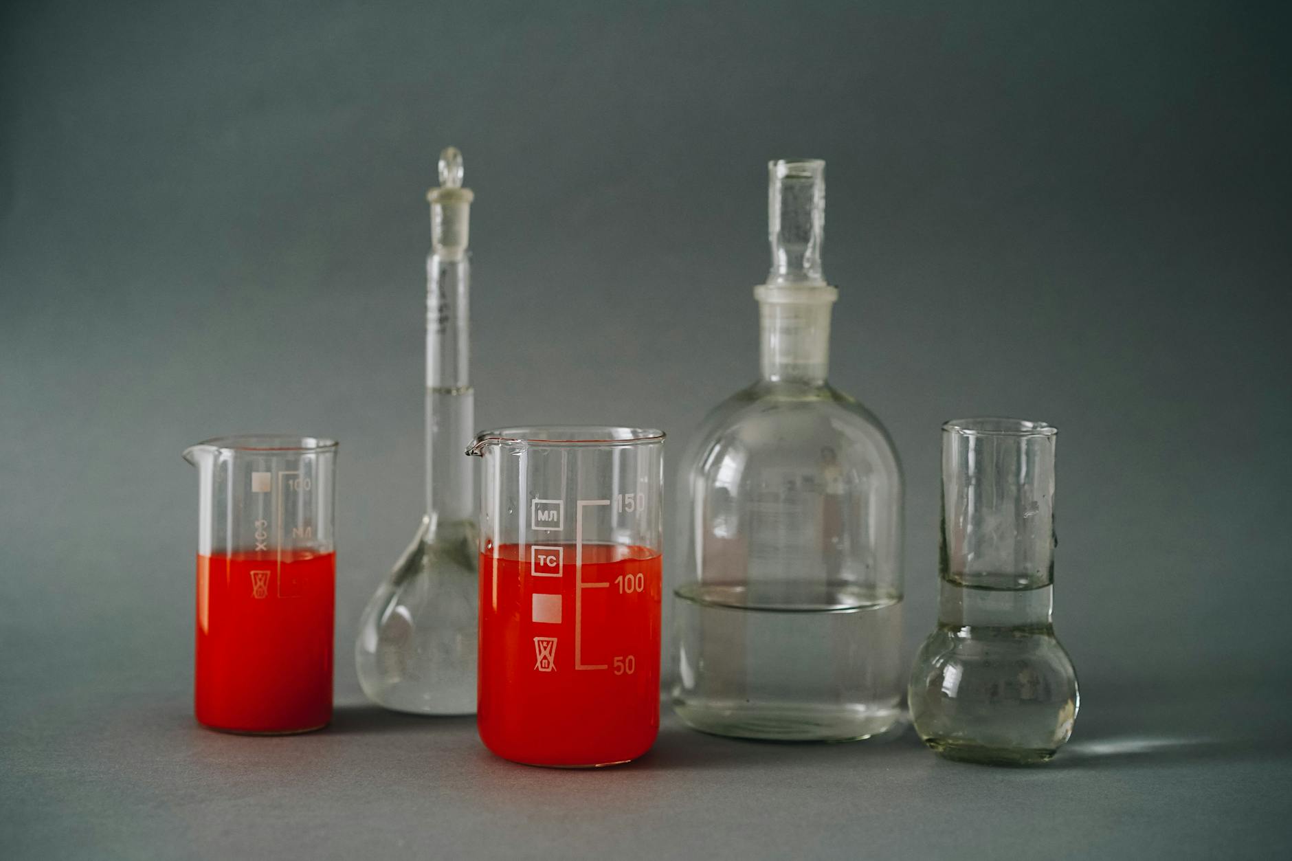 Close-up of laboratory glassware with colorful red liquids used in a chemistry lab — UPI Study