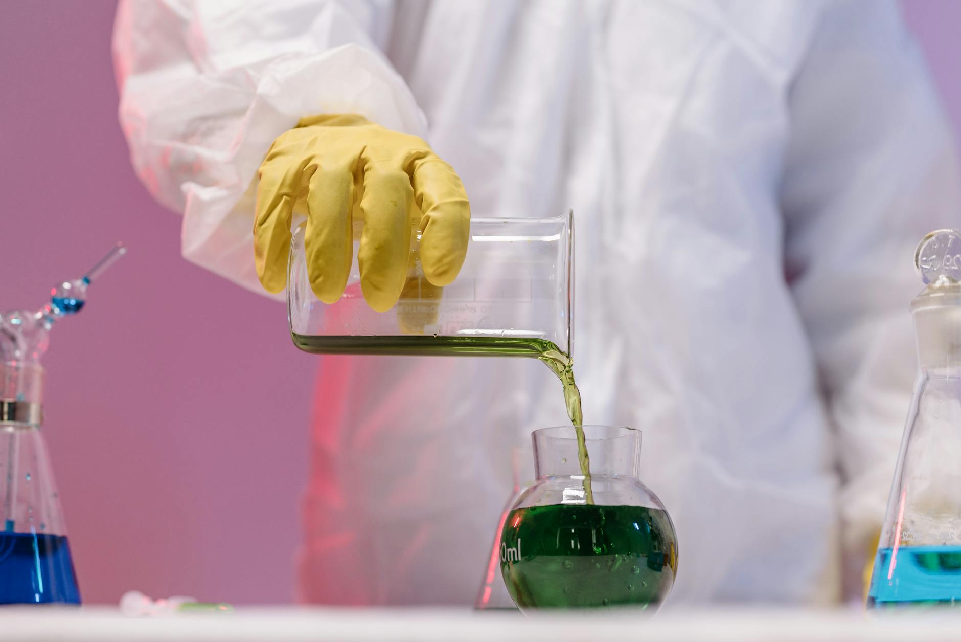 Scientist in protective gear pouring green liquid in a lab setting — UPI Study