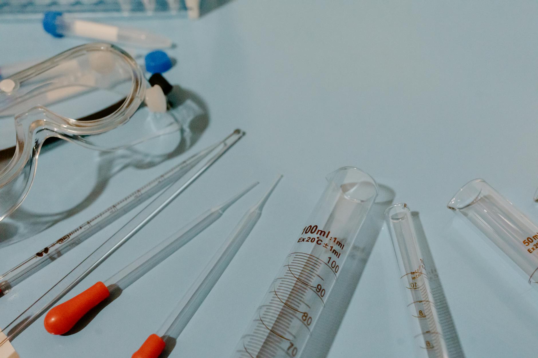 Detailed view of lab equipment like test tubes and goggles on a blue surface — UPI Study
