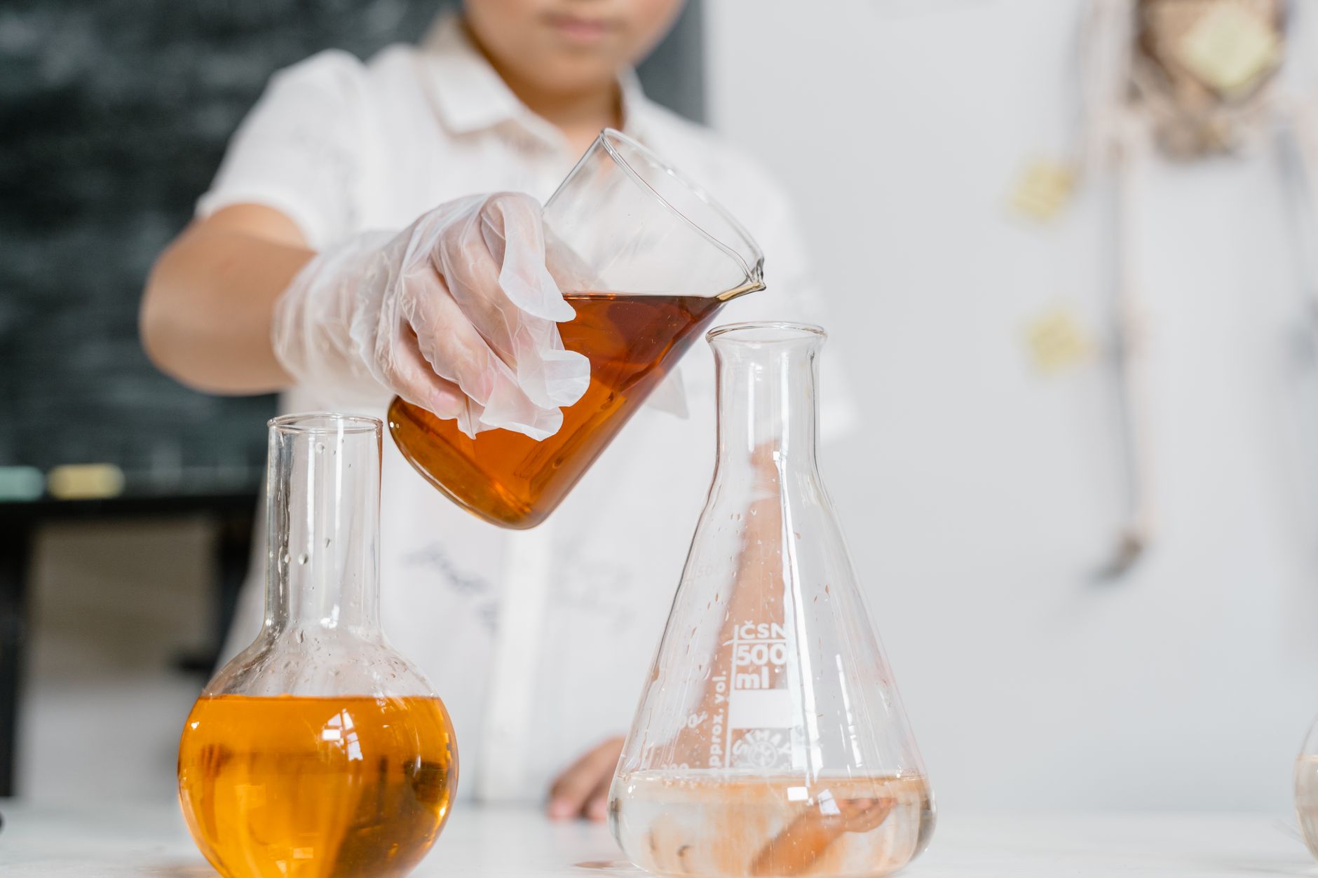 Scientist performing an experiment by pouring liquid into a flask — UPI Study