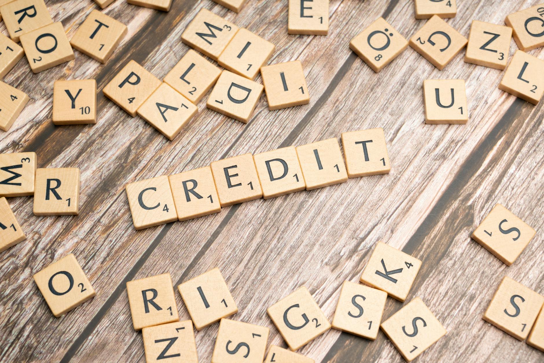 Wooden letter tiles arranged to spell 'CREDIT' on a rustic table background — UPI Study