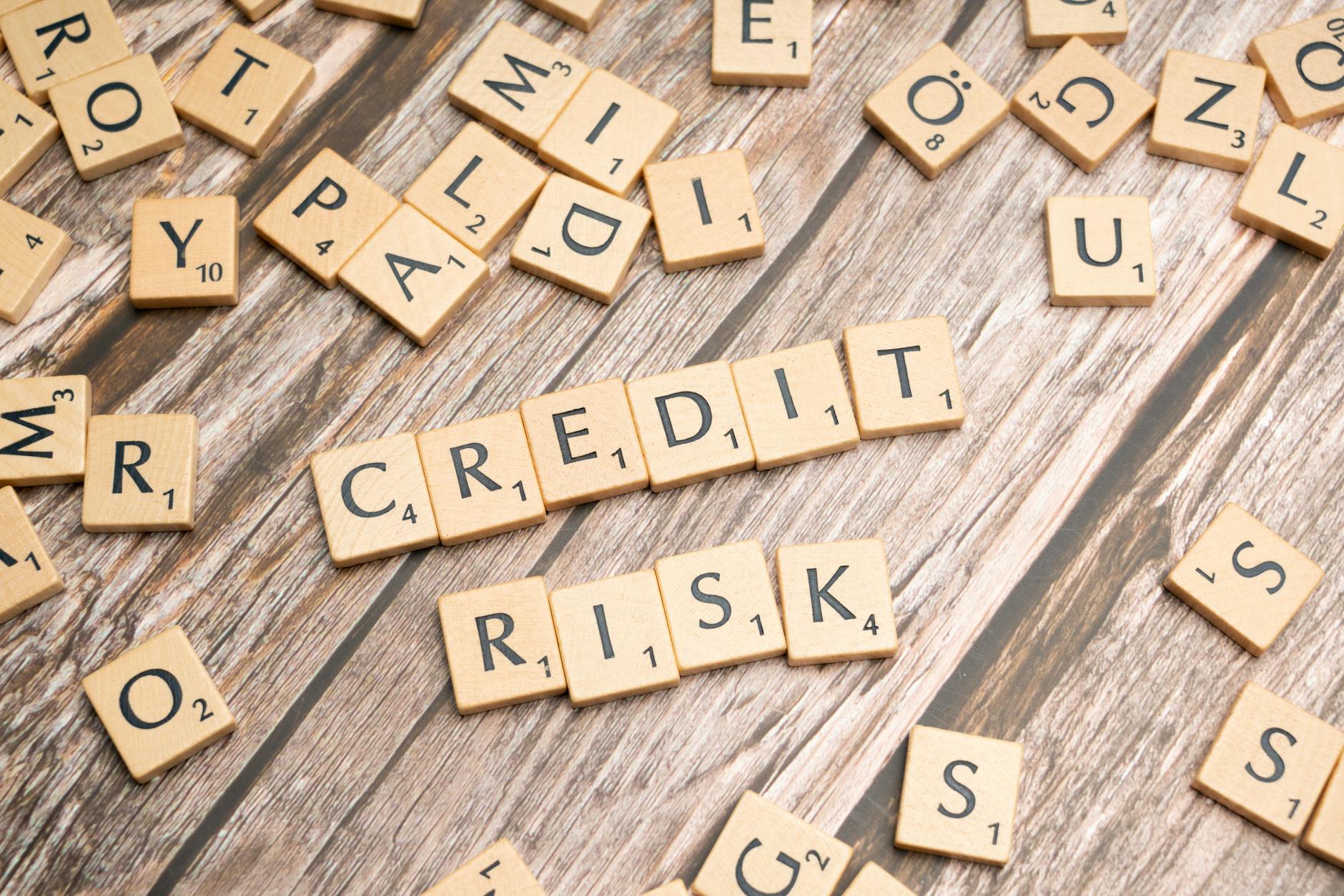 Scattered wooden letter tiles spelling 'credit risk' on a rustic wooden surface — UPI Study