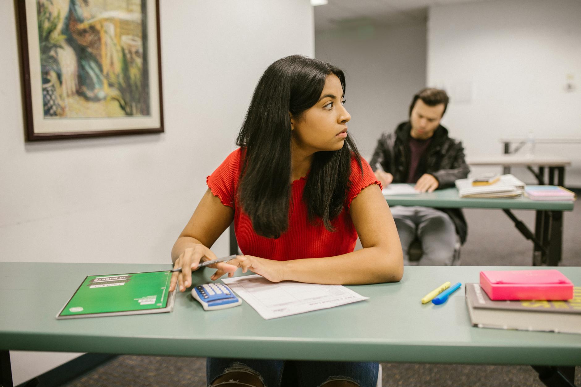 Students taking a test in a classroom, with one woman looking sideways. Education theme — UPI Study