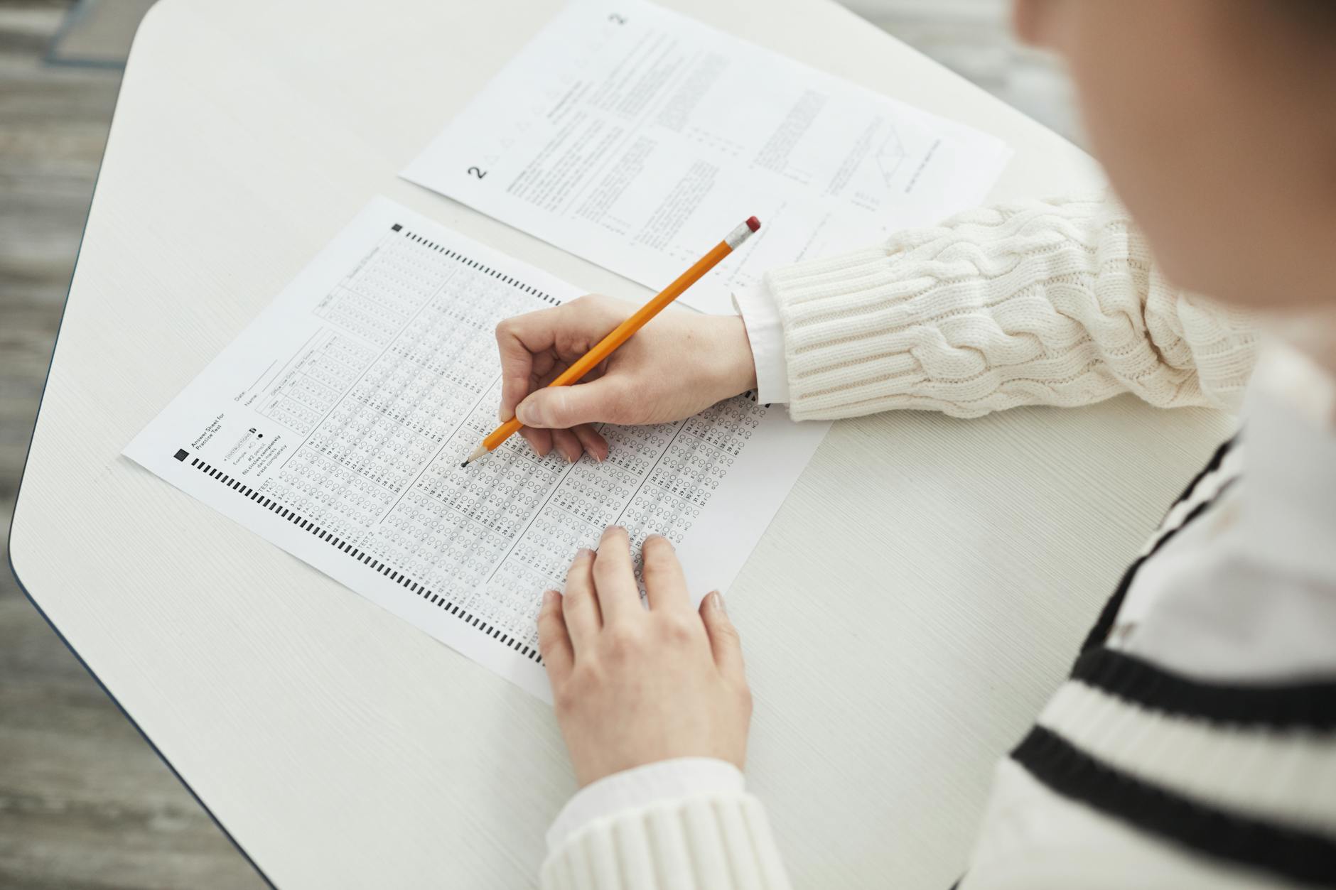 Close-up of a student filling out a multiple-choice exam in a quiet classroom setting — UPI Study