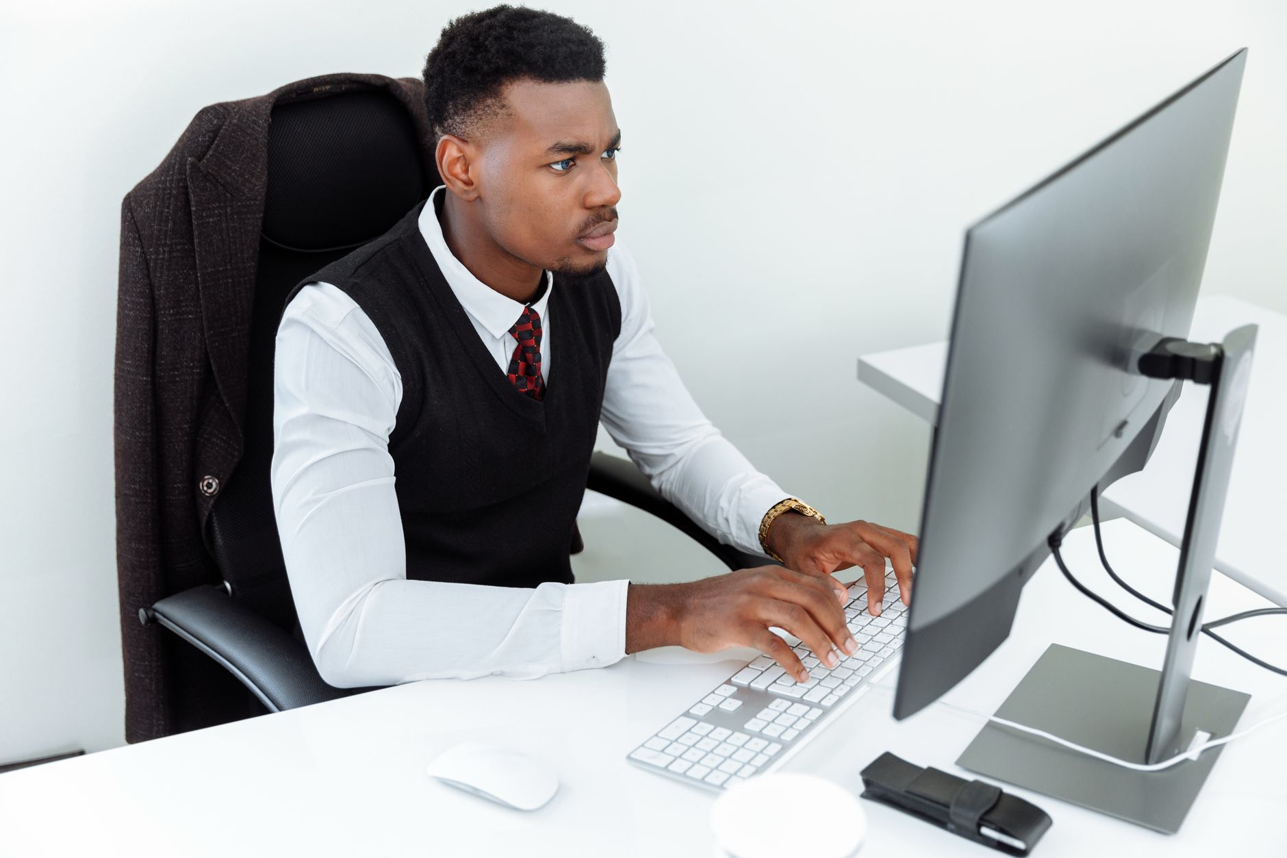 Professional man intensely working on a computer at his office desk, focused and determined in a business environment — UPI Study