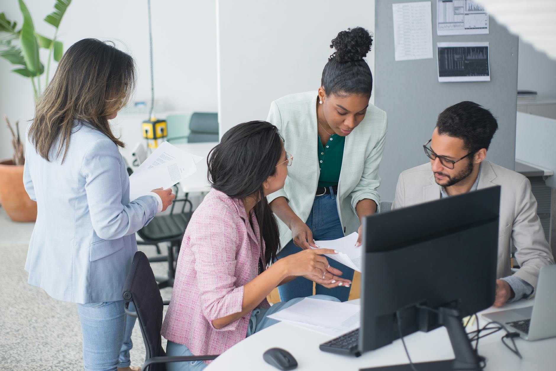 A diverse team engaged in a lively discussion in a modern office setting, fostering collaboration and teamwork — UPI Study