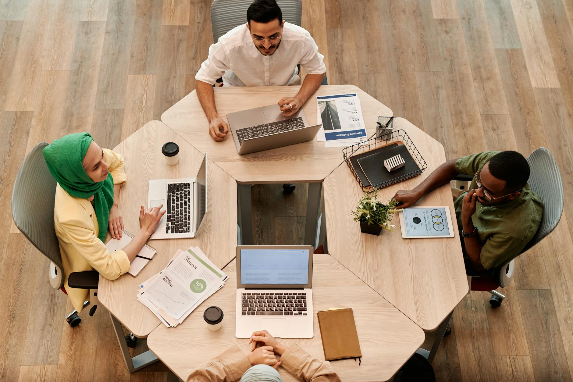 Top view of diverse coworkers collaborating at a modern office table — UPI Study