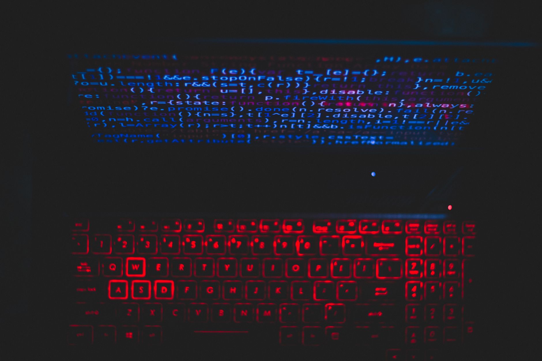 Dark-themed laptop setup with a red glowing keyboard and code on screen, ideal for tech enthusiasts — UPI Study