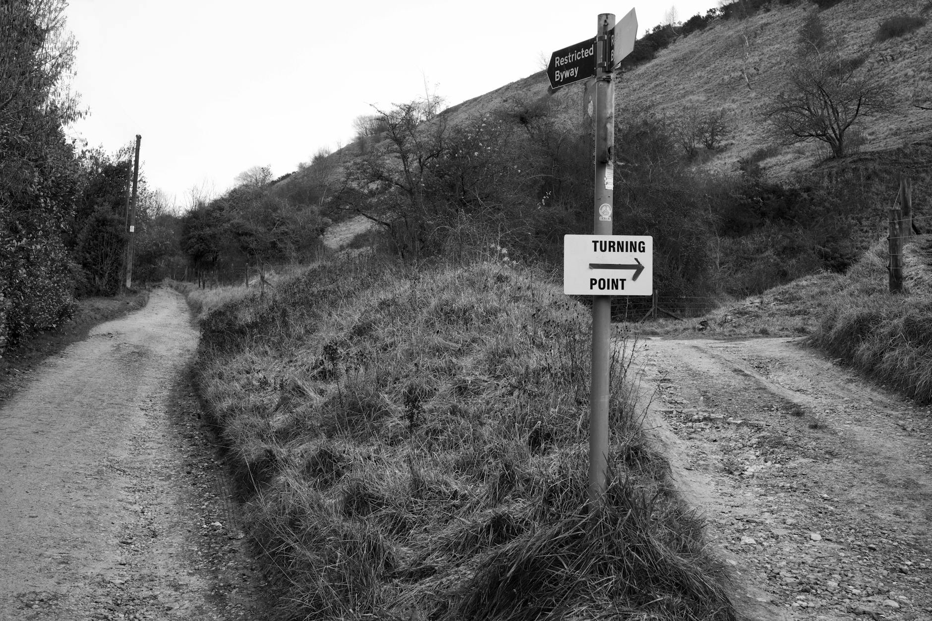 Black and white photo of a turning point in the Cheltenham countryside with directional signs — UPI Study