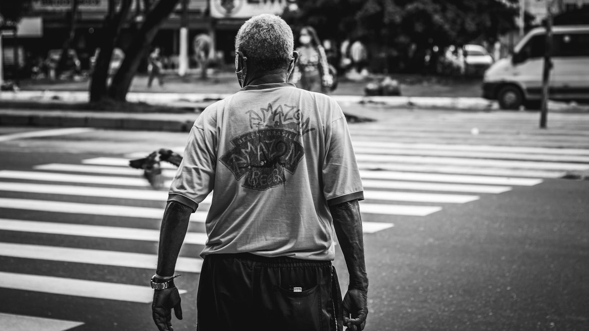 Black and white image of a man crossing a pedestrian lane in an urban setting — UPI Study