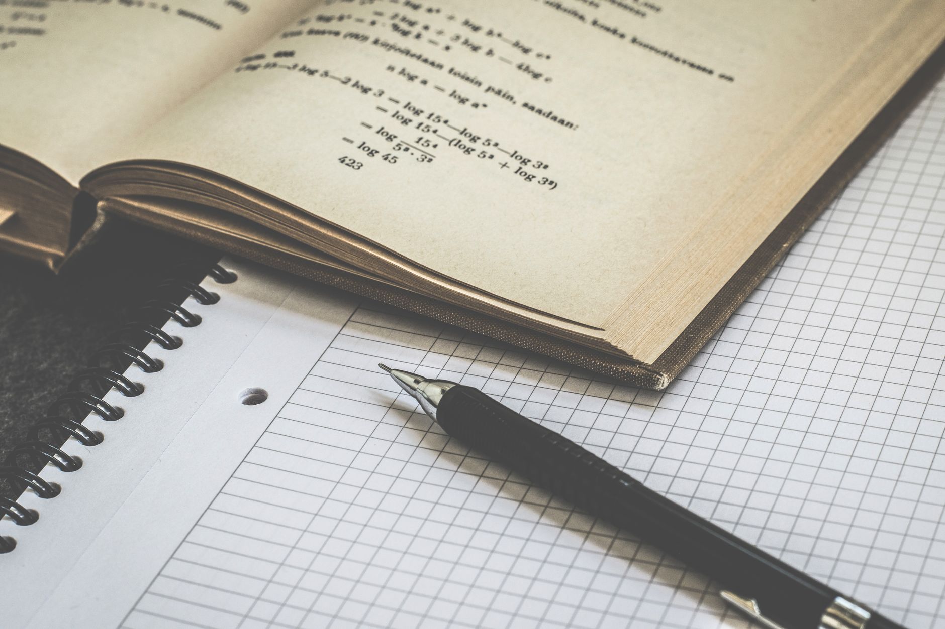Mathematical study scene with open book, graph paper, and pen for learning and homework — UPI Study