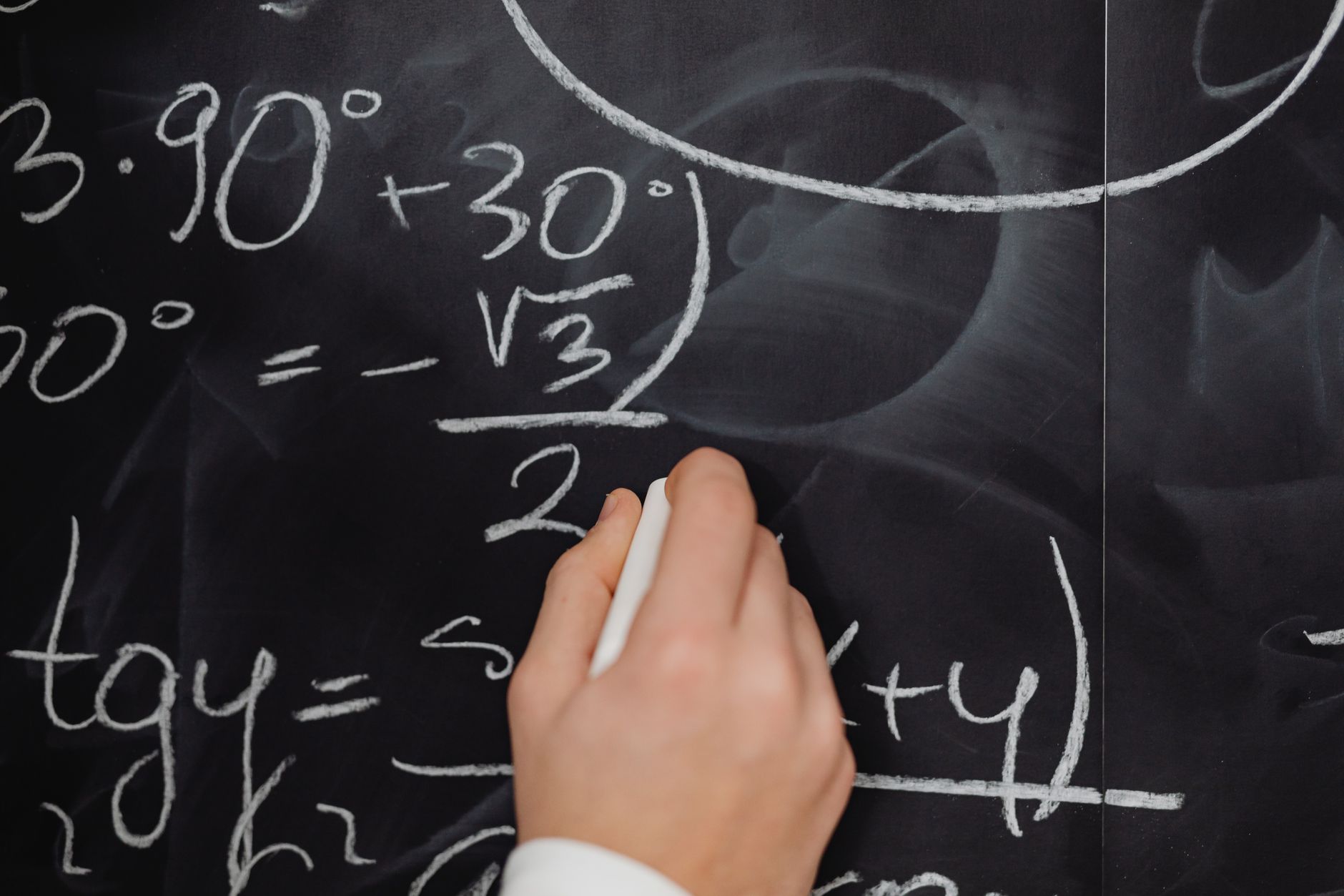 A hand vividly writing complex mathematical equations on a chalkboard — UPI Study