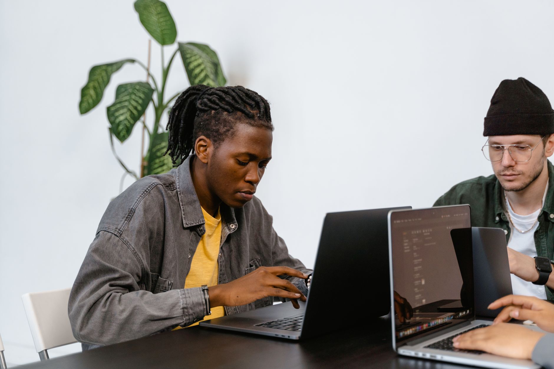 Two young adults working together on laptops in an office setting, focusing on tasks — UPI Study
