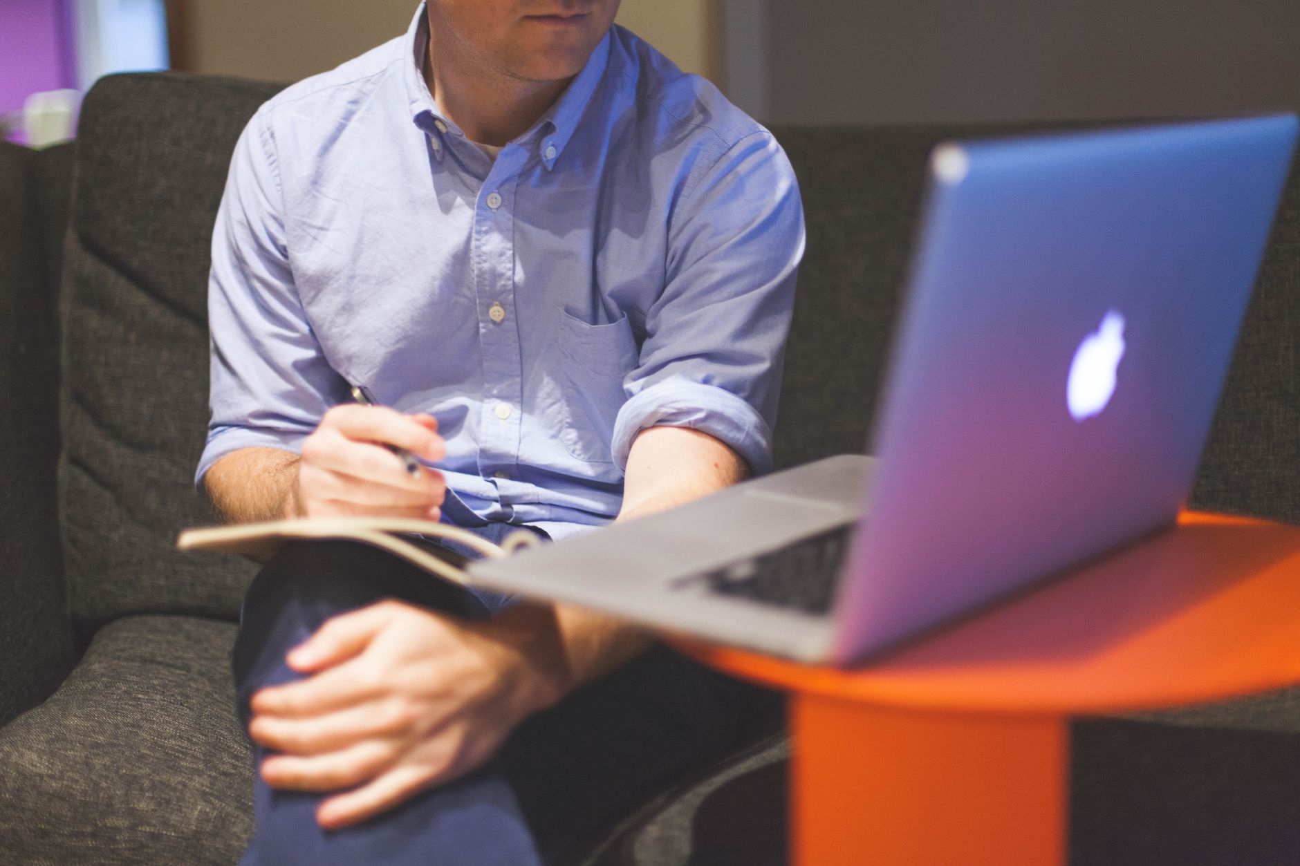 Man working remotely with laptop and notebook, noting ideas — UPI Study