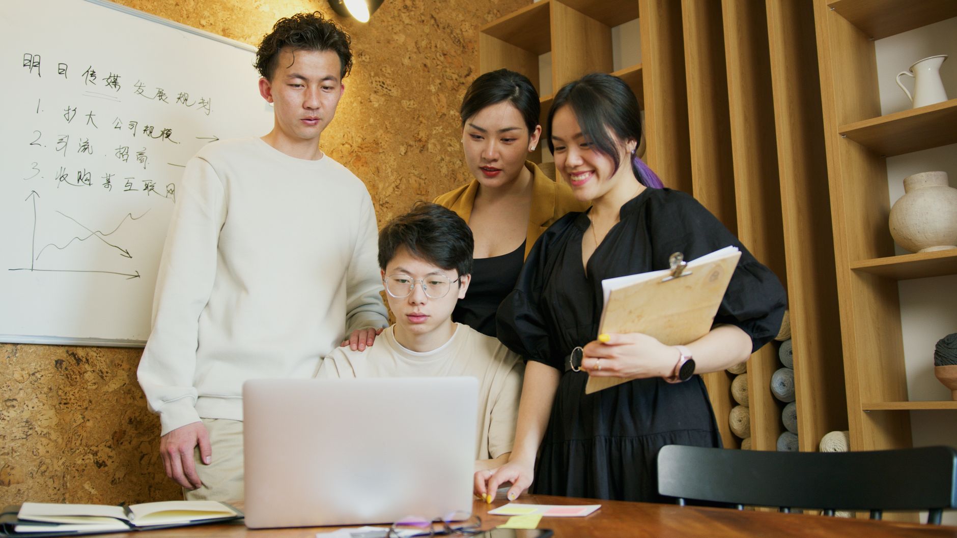 A group of young professionals working together on a project in a modern office setting — UPI Study