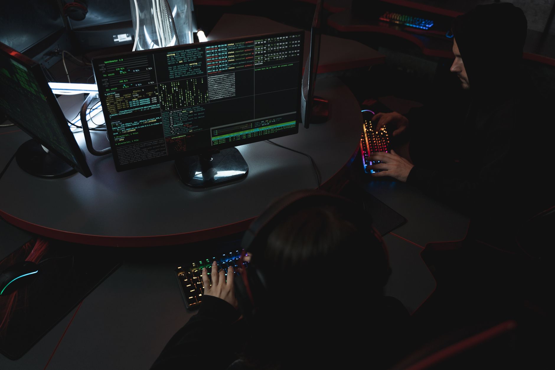 A group of people in a dark room working on computers, related to cybersecurity — UPI Study
